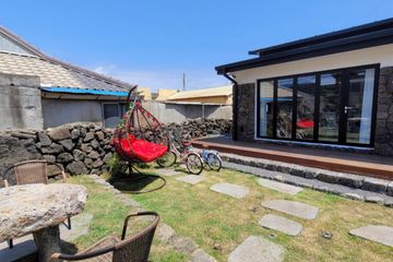Two-story house with a yard/stone wall