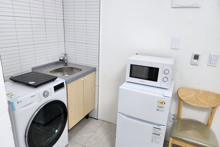 Clean white and gray studio apartment 3th image