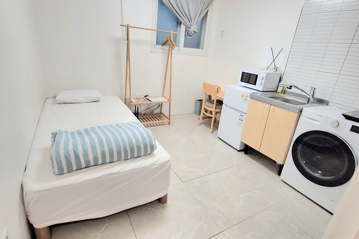 Clean, modern white studio apartment 11th image