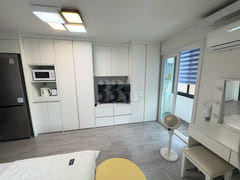 Fully furnished white-themed room in Junghwas 5th image