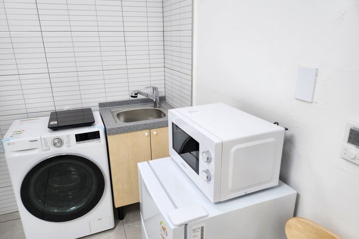 Clean white and gray studio apartment 8th image